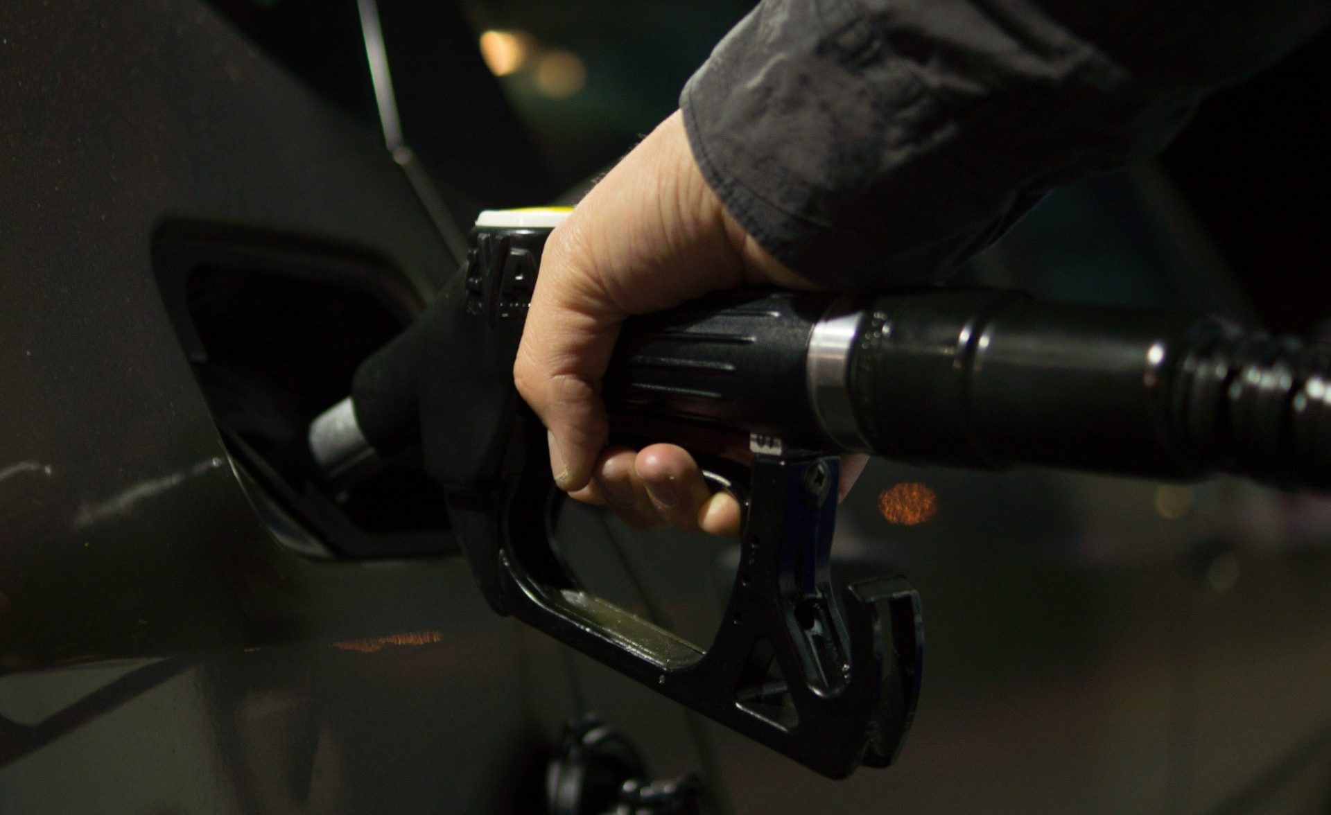 Close up of person fuelling car at gas pump