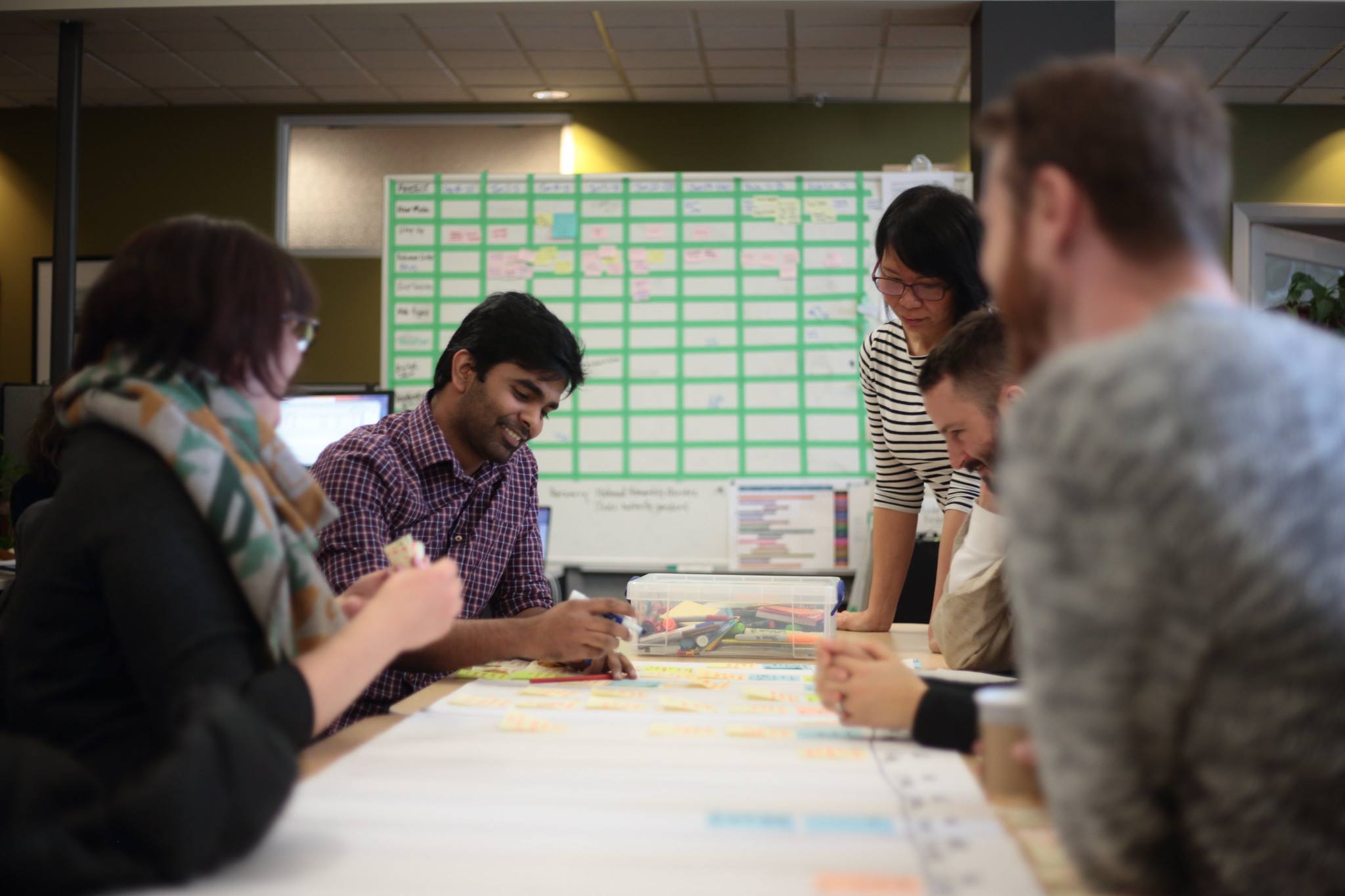 Coworkers leaning over large table working