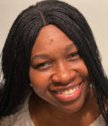 close up image of a smiling woman with braids.