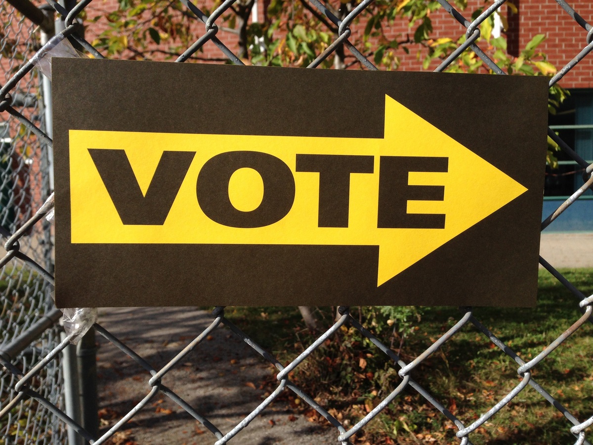 Sign hung on fence that says VOTE