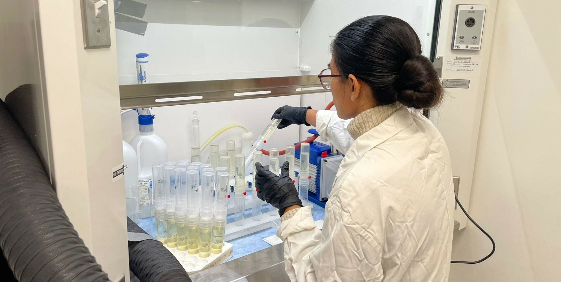 A woman handling test tubes in a lab
