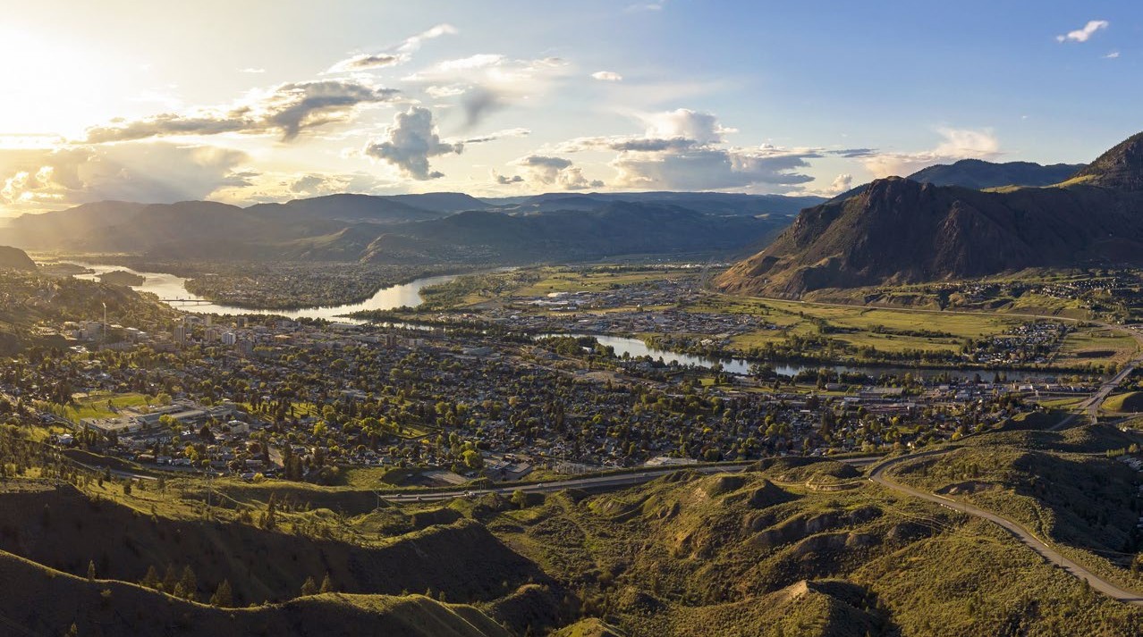 A landscape photo with grasslands and silt bluffs in the foreground.