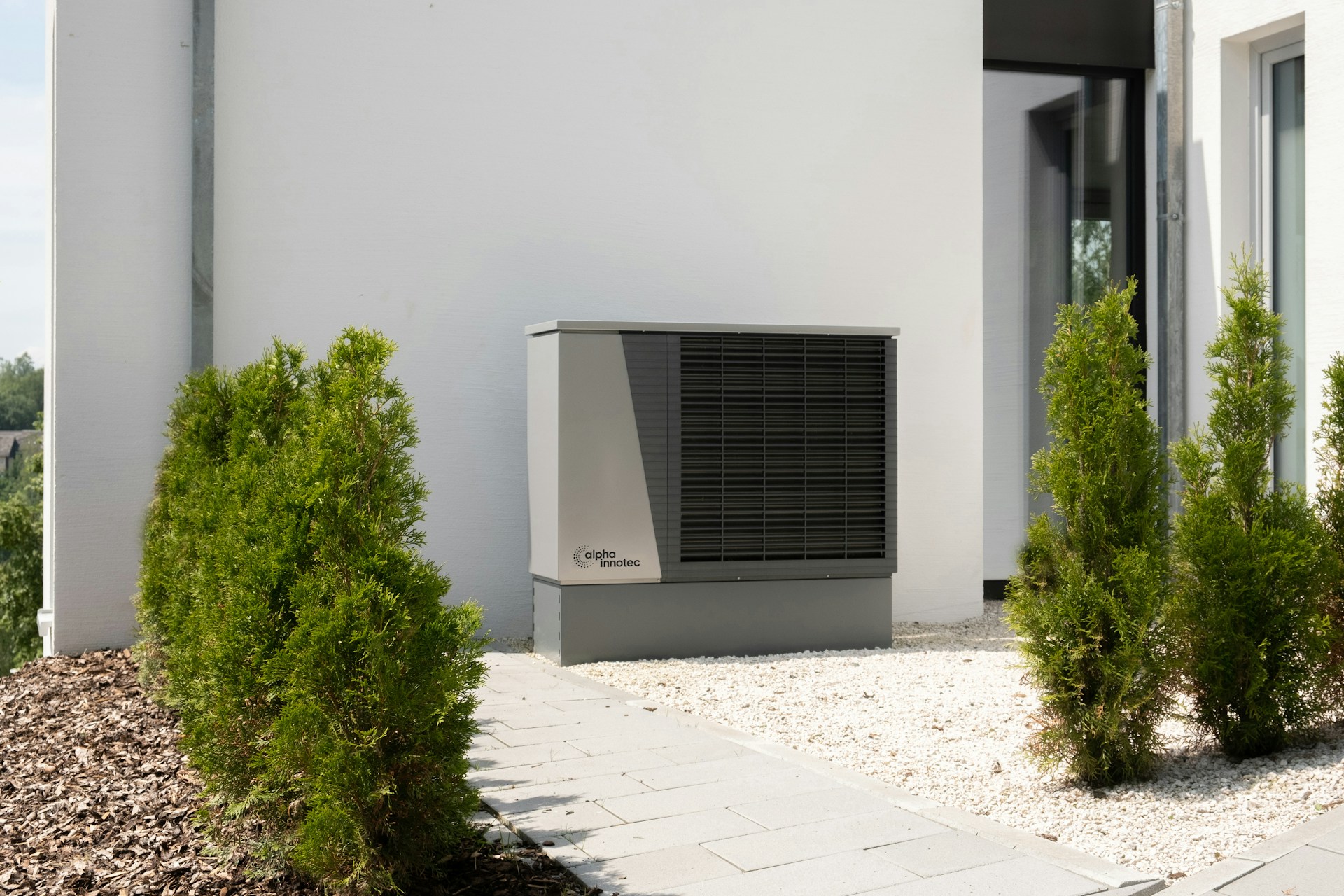 A heat pump installed outside a white building